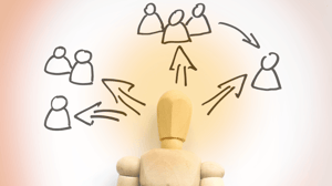 wooden man pointing to other people
